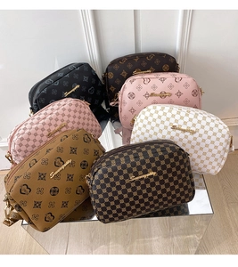 Group display of printed leather crossbody bags in various colors on a mirrored stand