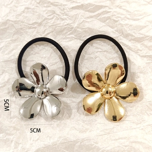 Detailed view of 5cm hollow alloy flower hair ties in gold and silver metallic finishes