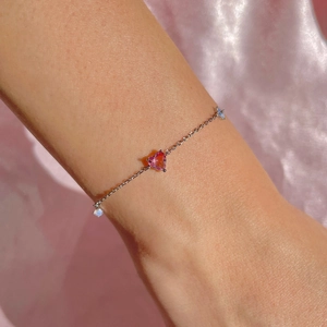 Detailed view of pink heart zircon bracelet on wrist with elegant silver-toned link chain