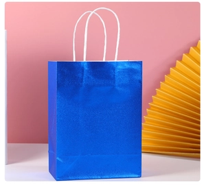 Detail of blue glitter gift bag made of kraft paper with white twisted paper handles