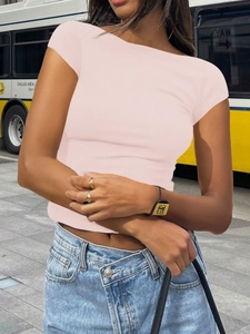 Détail style urbain d'un t-shirt rose ajusté avec un jean à taille asymétrique moderne