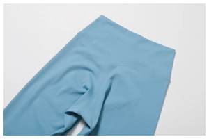 Détail d'un pantalon de yoga taille haute montrant les coutures plates et la texture du tissu