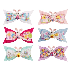 Detail of six colorful Easter bow clips with rabbit resin charms and printed ribbons