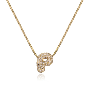 Macro detail of gold bubble letter P pendant necklace paved with sparkling cubic zirconia