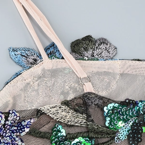 Détails des bretelles roses et broderie de paillettes colorées sur tulle noir