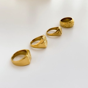 Set of four gold textured signet rings including hammered and meteorite crater styles