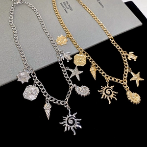 Detail of gold and silver necklaces featuring sea star and turtle charms on a book