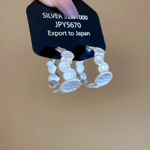 Detail of 925 sterling silver C-shape earrings featuring unique bubble hammer texture