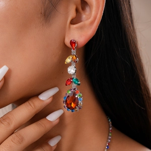 Close-up of model wearing elegant long tassel earrings with multicolored crystal stones