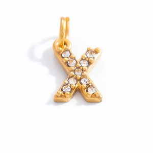 Detail of 18K gold letter X pendant featuring high-quality white cubic zirconia inlay