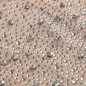 Detailed macro view of mesh fabric with hand-set rhinestones for evening gown