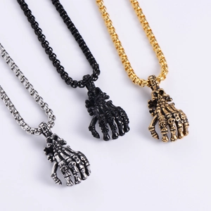 Detailed view of punk skull hand pendants in antique silver, matte black, and gold finishes