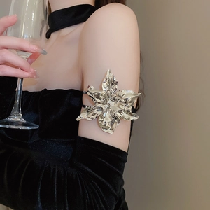 Detailed view of silver metallic oversized flower arm cuff with polished layered petals
