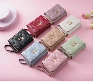 Detailed view of quilted faux leather wallets with elegant embroidery and metal clasps