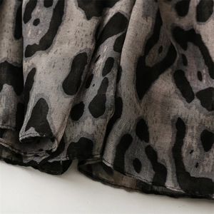 Close-up of grey leopard print fabric showing lightweight texture and hem stitching