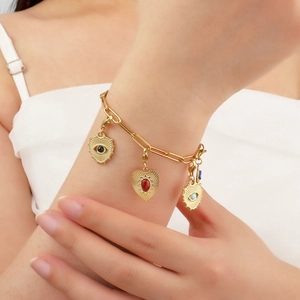 Golden chain bracelet with heart-shaped evil eye pendants in black, red, and blue