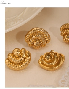 Detail of gold-plated hammered metal stud earrings in a vintage half-round shell shape