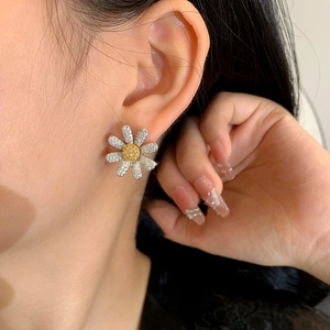 Daisy flower earrings with silver petals and zircon centers worn on a female model