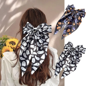 Detail of Halloween satin bow hair clip featuring ghost and pumpkin print on a model