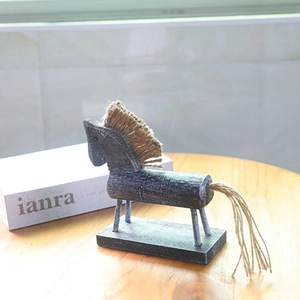 Dettaglio di statuetta vintage in legno fatta a mano con criniera e coda in juta naturale