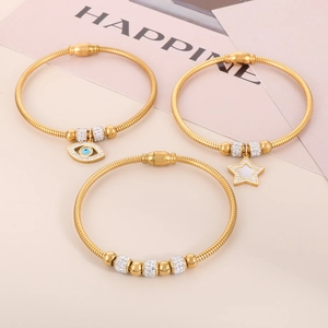 Detailed view of three gold snake chain bracelets featuring evil eye and star charms