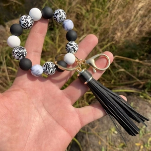 Detailed macro view of leopard print beads and black PU tassel on the keychain ring