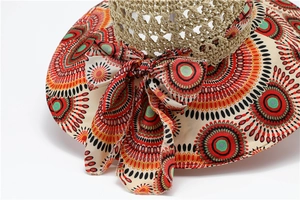 Detail of bohemian sun hat featuring colorful polka dot patterns and large fabric bow