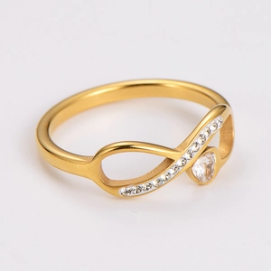 Detailed close-up of gold infinity ring with sparkling heart crystal and paved stones