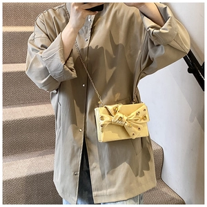 Elegant yellow satin evening clutch featuring a large decorative bow with gold accents