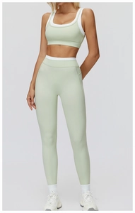 Detail of high-stretch sage green ribbed yoga set with white contrast trim and high waist