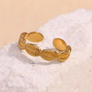 Macro detail of adjustable gold-plated shell-shaped stainless steel ring with fine texture