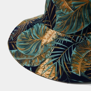 Détail de l'imprimé palmier tropical sur un chapeau de soleil bleu foncé à large bord