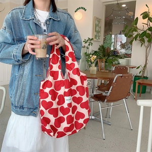 Corduroy tote bag with red heart pattern shown in a cozy cafe setting for daily use