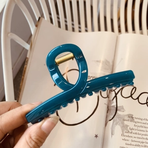 Détail de la pince à cheveux bleu paon élégante avec ressort en métal doré
