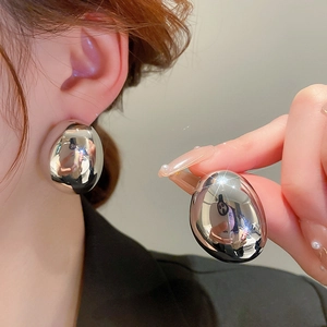 Polished silver teardrop earrings with fashion metal dangle design shown on a model
