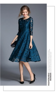 Detailed texture of dark blue floral lace dress with semi-sheer three-quarter sleeves