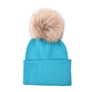 Detail showing knit texture of the lake blue beanie and large fluffy pompom accessory