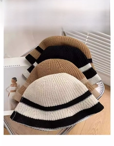 Detailed close-up of three striped knit bucket hats in beige, khaki, and brown shades