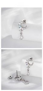Detail of crescent moon earring with zircon accents and teardrop pendant on white silk