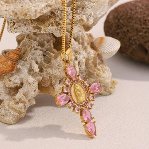 Détail du collier croix plaqué or 18 carats avec cristal rose et relief de Marie