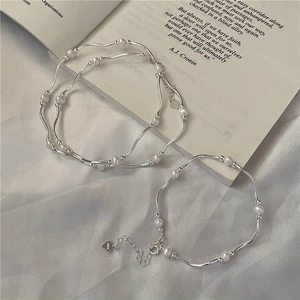 Handcrafted S925 sterling silver pearl bracelet with wavy bar design on white silk fabric