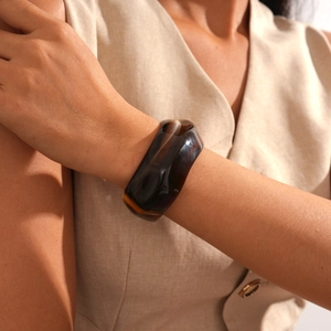 Detail view of wide translucent resin cuff bracelet with polished amber-like finish