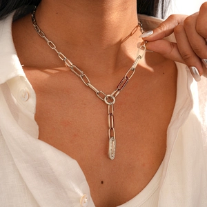 Close-up of a silver Y-shaped paperclip chain necklace with diamond-set ring and links