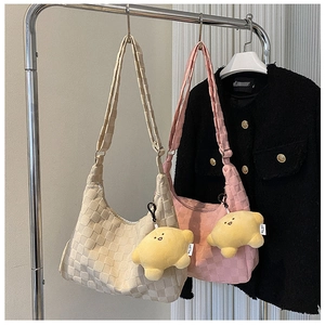 Detail of checkered shoulder bags in beige and pink with yellow star plush pendants