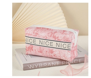 Close-up of pink patterned PVC cosmetic bag with NICE NICE NICE lettered strap