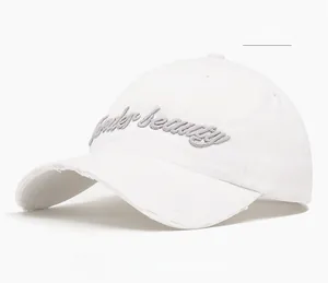Detail of white cotton baseball cap with 3D embroidery and distressed brim edge