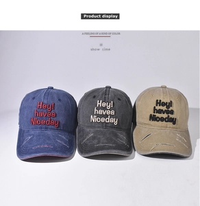 Detail der Stickerei 'Hey! have a Nice day' auf gewaschenen Vintage-Baseballkappen