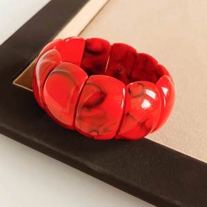 Macro detail of red marble texture acrylic chunky bracelet with geometric resin links