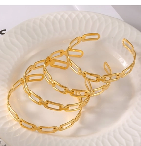 Détail d'un ensemble de trois bracelets en acier titane doré avec maillons géométriques