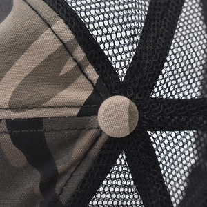 Close-up detail of camouflage fabric stitching and breathable black mesh on baseball cap
